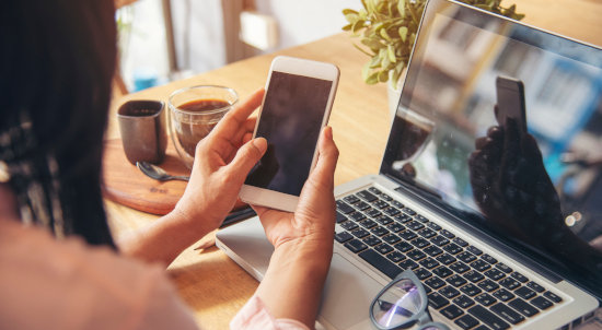 Dekorativ: Frau arbeitet an Handy und Laptop